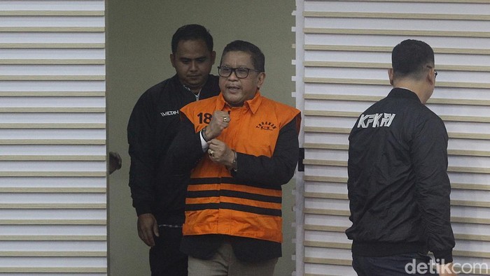 Sekjen PDI Perjuangan Hasto Kristiyanto mengenakan rompi tahanan dengan tangan terborgol saat proses penahanan di Gedung Merah Putih KPK, Jakarta, Kamis (20/2/2025). Hasto beberapa kali mengepalkan tangan dan tersenyum ke awak media. Hasto ditahan sebagai tersangka dalam kasus dugaan suap kepada komisioner KPU terkait pergantian antarwaktu (PAW) anggota DPR yang melibatkan Harun Masiku, serta perintangan penyidikan