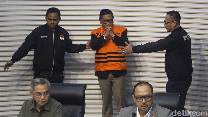 Sekjen PDI Perjuangan Hasto Kristiyanto mengenakan rompi tahanan dengan tangan terborgol saat proses penahanan di Gedung Merah Putih KPK, Jakarta, Kamis (20/2/2025). Hasto beberapa kali mengepalkan tangan dan tersenyum ke awak media. Hasto ditahan sebagai tersangka dalam kasus dugaan suap kepada komisioner KPU terkait pergantian antarwaktu (PAW) anggota DPR yang melibatkan Harun Masiku, serta perintangan penyidikan