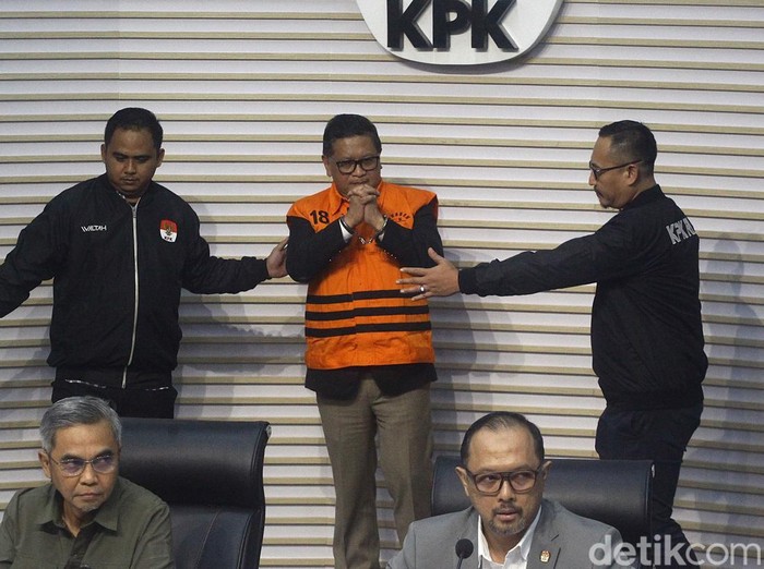 Sekjen PDI Perjuangan Hasto Kristiyanto mengenakan rompi tahanan dengan tangan terborgol saat proses penahanan di Gedung Merah Putih KPK, Jakarta, Kamis (20/2/2025). Hasto beberapa kali mengepalkan tangan dan tersenyum ke awak media. Hasto ditahan sebagai tersangka dalam kasus dugaan suap kepada komisioner KPU terkait pergantian antarwaktu (PAW) anggota DPR yang melibatkan Harun Masiku, serta perintangan penyidikan