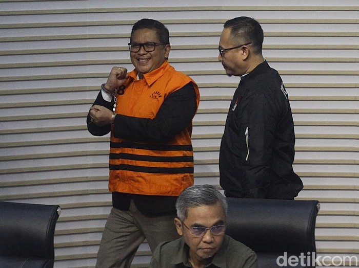 Sekjen PDI Perjuangan Hasto Kristiyanto mengenakan rompi tahanan dengan tangan terborgol saat proses penahanan di Gedung Merah Putih KPK, Jakarta, Kamis (20/2/2025). Hasto beberapa kali mengepalkan tangan dan tersenyum ke awak media. Hasto ditahan sebagai tersangka dalam kasus dugaan suap kepada komisioner KPU terkait pergantian antarwaktu (PAW) anggota DPR yang melibatkan Harun Masiku, serta perintangan penyidikan