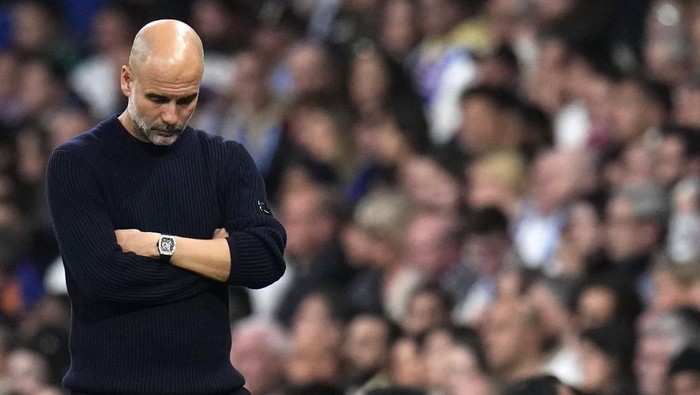 Manchester Citys head coach Pep Guardiola grimaces during the Champions League playoff second leg soccer match between Real Madrid and Manchester City at the Santiago Bernabeu Stadium in Madrid, Spain, Wednesday, Feb. 19, 2025. (AP Photo/Manu Fernandez)