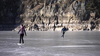 Sungai yang membeku ini dimanfaatkan sebagian warga untuk bermain ice skating.