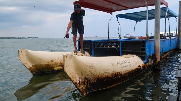 Tumpahan Oli di Pantai Bangsring Ancam Konservasi Terumbu Karang Pengelola menunjukan tumpahan oli yang mengotori perahu wisata di Pantai Bangsring, Banyuwangi, Jawa Timur, Rabu (19/2/2025). Sudah 3 hari tumpahan oli yang tidak diketahui sumber nya itu mencemari Pantai Bangsring yang menjadi tempat wisata dan zona konservasi terumbu karang seluas 15 hektare sehingga mengancam ke berlangsungan hidup biota laut. ANTARA FOTO/Budi Candra Setya/nz