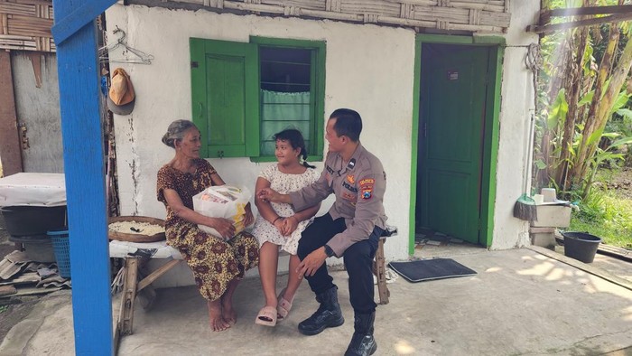 Aipda Lucky bersama putrinya berbincang dengan nenek sebatang kara di Sidoarjo.
