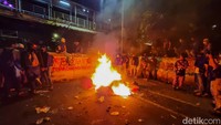 Selanjutnya, sejumlah orang terlihat membawa water barier yang digunakan untuk menutup jalan ke arah barier beton. Water barier itu kemudian dibakar oleh sekelompok orang di depan barier beton.