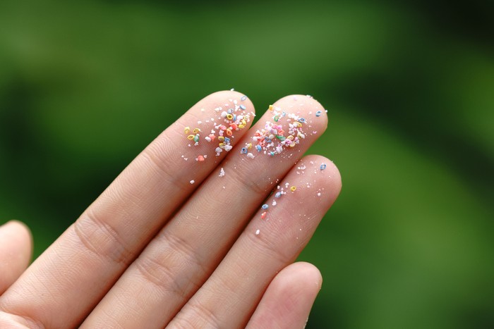 Close up side shot of microplastics lay on people hand.Concept of water pollution and global warming. Climate change idea.