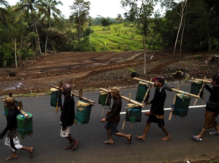 Warga kaum adat Bonokeling membawa hasil bumi saat melakukan ritual laku mlampah atau ritual jalan kaki menuju makam Kyai Bonokeling  dengan membawa hasil bumi di Desa Pekuncen, Banyumas, Jawa Tengah, Kamis (20/2/2025). Laku mlampah merupakan awal dimulainya ritual perlon unggahan di komplek makam Kyai Bonokeling, dimana masing-masing warga berjalan kaki dari rumah membawa hasil bumi dan bahan makanan mentah hasil kebun dan pertanian mereka, yang akan dimasak dan dimakan bersama pada proses ritual perlon unggahan. ANTARA FOTO/Idhad Zakaria/YU