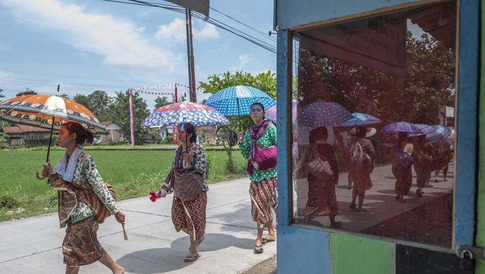 Warga kaum adat Bonokeling membawa hasil bumi saat melakukan ritual laku mlampah atau ritual jalan kaki menuju makam Kyai Bonokeling  dengan membawa hasil bumi di Desa Pekuncen, Banyumas, Jawa Tengah, Kamis (20/2/2025). Laku mlampah merupakan awal dimulainya ritual perlon unggahan di komplek makam Kyai Bonokeling, dimana masing-masing warga berjalan kaki dari rumah membawa hasil bumi dan bahan makanan mentah hasil kebun dan pertanian mereka, yang akan dimasak dan dimakan bersama pada proses ritual perlon unggahan. ANTARA FOTO/Idhad Zakaria/YU