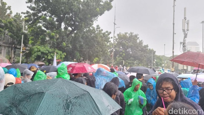 Massa aksi Indonesia Gelap bertahan di Patung Kuda Jakpus meski hujan turun.