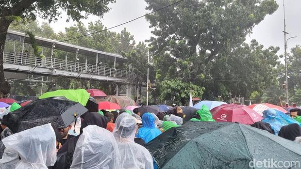 Massa aksi Indonesia Gelap bertahan di Patung Kuda Jakpus meski hujan turun.