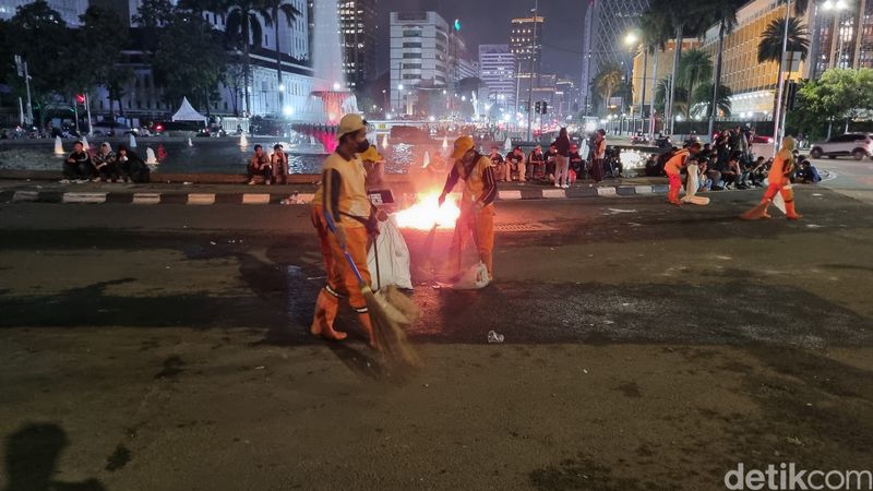 Pasukan oranye atau petugas PPSU mulai bersih-bersih di lokasi demonstrasi, 21 Februari 2025 malam. (Taufiq S/detikcom)