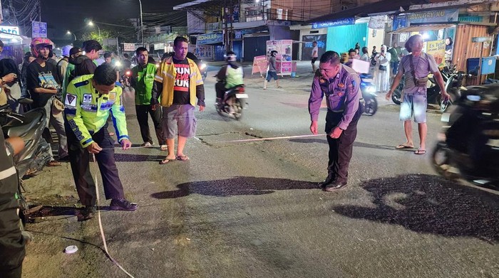 Polisi saat melakukan olah TKP kecelakaan driver ojol wanita yang tewas ditabrak sepeda motor