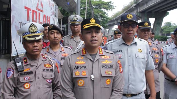 Polres Metro Jakarta Barat membagikan helm gratis kepada pengendara motor dalam rangka Operasi Keselamatan 2025