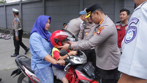 Polres Metro Jakarta Barat membagikan helm gratis kepada pengendara motor dalam rangka Operasi Keselamatan 2025