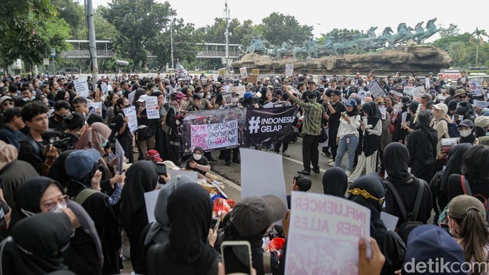 Massa aksi 'Indonesia Gelap' berkumpul di sekitar Patung Kuda, Jakarta Pusat, Jumat (21/2/2025). Mereka tampak mengenakan pakaian serba hitam.