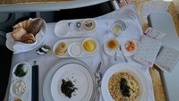 Shandy menunjukkan caviar, ramen, dan aneka roti yang ia nikmati di penerbangan first class. Foto: Instagram @shandyaulia