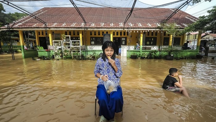 Sekolah terdampak banjir di Jambi Guru dan murid berada di halaman SDN 98 Kota Jambi yang terendam banjir luapan Sungai Kenali Asam di Suka Karya, Jambi, Jumat (21/2/2025). Aktivitas belajar mengajar 386 murid di sekolah yang telah mengalami banjir keempat dalam tahun ini tersebut terpaksa diliburkan. ANTARA FOTO/Wahdi Septiawan/foc.
