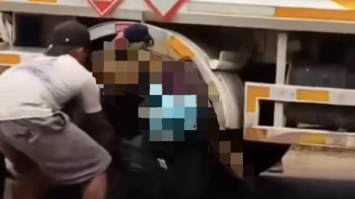 Warga saat membantu mengevakuasi jasad korban yang terjepit roda truk