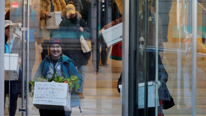Recently fired U.S. Agency for International Development (USAID) staff react as they leave work and are applauded by former USAID staffers and supporters during a sendoff outside USAID offices in Washington, D.C., U.S., February 21, 2025.   REUTERS/Brian Snyder