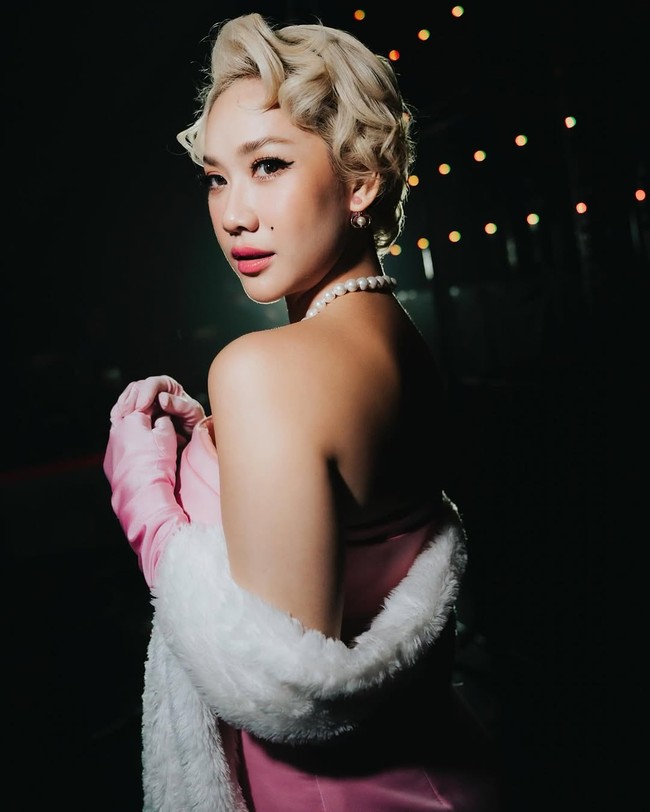 Sentuhan glamor semakin diperkuat dengan sarung tangan satin panjang berwarna senada, mantel bulu putih yang melingkupi bahunya, serta aksesori mutiara yang memberikan nuansa old Hollywood. Foto: Instagram/@itsmebcl