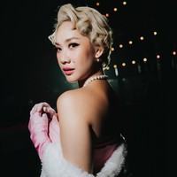 Sentuhan glamor semakin diperkuat dengan sarung tangan satin panjang berwarna senada, mantel bulu putih yang melingkupi bahunya, serta aksesori mutiara yang memberikan nuansa old Hollywood. Foto: Instagram/@itsmebcl