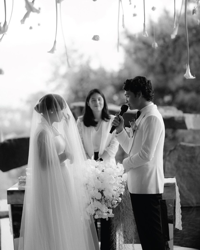 Saat berhadapan dengan Mikha di depan altar, Gregoria memakai veil panjang dan memegang hand bouquet bunga berwarna putih. Penampilannya dilengkapi kalung dan anting mutiara simple. Foto: dok. Instagram @venemapictures