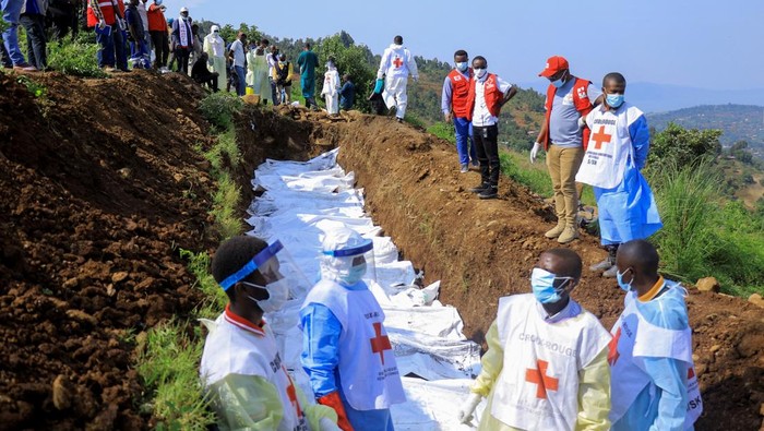 Pemakaman Massal Korban Tewas Bentrokan di Kongo Congolese Red Cross members bury in a mass grave the body bags containing the remains of victims killed in the recent clashes between M23 rebels and the Armed Forces of the Democratic Republic of the Congo (FARDC), at the Musigoko cemetery in Bukavu, eastern Democratic Republic of Congo February 20, 2025. REUTERS/Victoire Mukenge