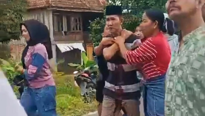Kades Ulak Segelung Ogan Ilir Muhammad alias Mamat memegang bahu usai ditusuk warganya.