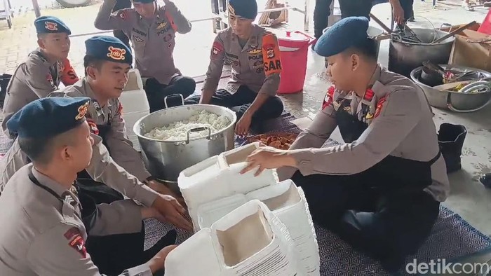 Personel Brimob Polda Lampung sibuk memasak makanan untuk korban banjir.