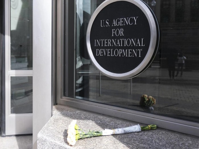 Karangan bunga diletakkan di luar markas besar USAID di Washington DC, AS. (AP Photo/Manuel Balco Ceneta)