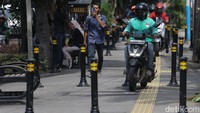 Tidak hanya satu, namun ada beberapa pengguna sepeda motor yang masuk trotoar.
