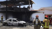 Petugas pemadam kebakaran bekerja di sekitar lokasi jatuhnya pesawat kecil ke sebuah rumah di distrik San Bartolo, Lima, Peru, Sabtu (22/2/2025).