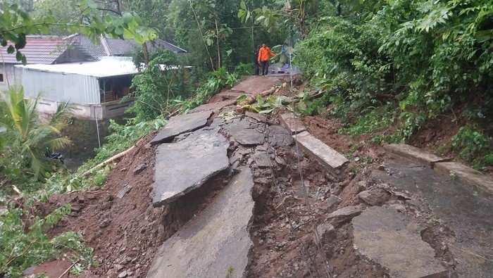 Petugas saat mendatangi lokasi jalan desa yang ambrol akibat tanah longsor di Bojong, Wonolelo, Pleret, Bantul, Senin (24/2/2025).