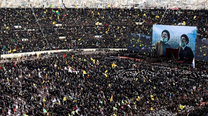 Potret Lautan Manusia Iringi Pemakaman Pemimpin Hizbullah Hassan Nasrallah Mourners gather on the day of a public funeral ceremony for late Hezbollah leaders Hassan Nasrallah and Hashem Safieddine, who were killed in Israeli airstrikes last year, in Camille Chamoun Sports City Stadium, on the outskirts of Beirut, Lebanon February 23, 2025. REUTERS/Thaier Al-Sudani