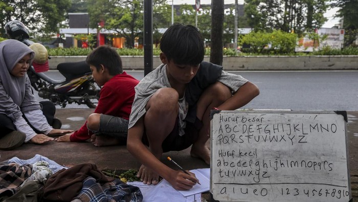 Seorang anak belajar menulis di lapak sekolah pinggir jalan gratis di Kota Serang, Banten, Senin (24/2/2025). Ruang belajar alternatif yang diinisiasi oleh mahasiswa dari berbagai universitas di Kota Serang serta digelar setiap Senin sore itu bertujuan untuk memberikan akses pendidikan bagi masyarakat umum khususnya anak-anak kurang mampu. ANTARA FOTO/Angga Budhiyanto/nym.