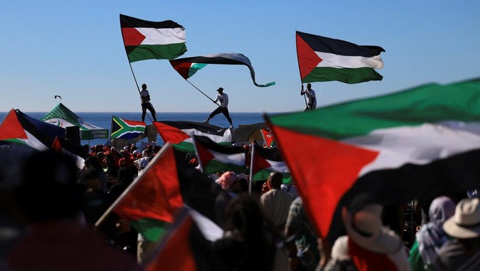 Pro-Palestinian demonstrators hold Palestinian flags, as they take part in a protest against U.S. President Donald Trumps plan to resettle Palestinians from Gaza, in Cape Town, South Africa, February 22, 2025. REUTERS/Esa Alexander