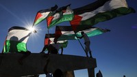 Warga tampak mengibarkan bendera Palestina.