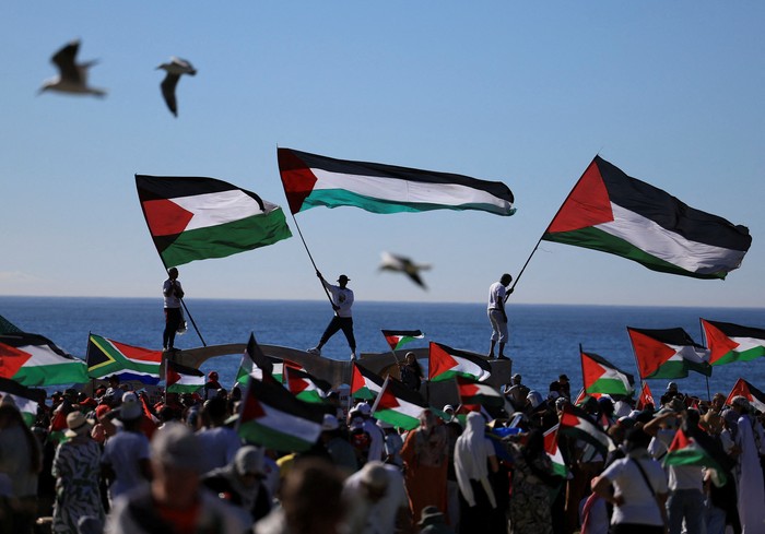 Pro-Palestinian demonstrators hold Palestinian flags, as they take part in a protest against U.S. President Donald Trumps plan to resettle Palestinians from Gaza, in Cape Town, South Africa, February 22, 2025. REUTERS/Esa Alexander