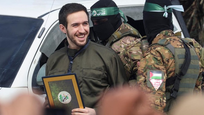 Omer Shem Tov, a hostage held in Gaza since the deadly October 7, 2023 attack, is escorted by Hamas militants as he is released as part of a ceasefire and a hostages-prisoners swap deal between Hamas and Israel, in Nuseirat, central Gaza Strip, February 22, 2025. REUTERS/Ramadan Abed