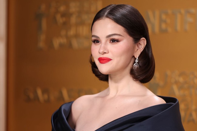 Untuk semakin memperkuat kesan mewah, Gomez mengenakan perhiasan berlian, termasuk anting berbentuk bunga dan beberapa cincin bertumpuk. Sepasang stiletto hitam bertali menyempurnakan penampilannya. Foto: Los Angeles Times via Getty Images/Christina House