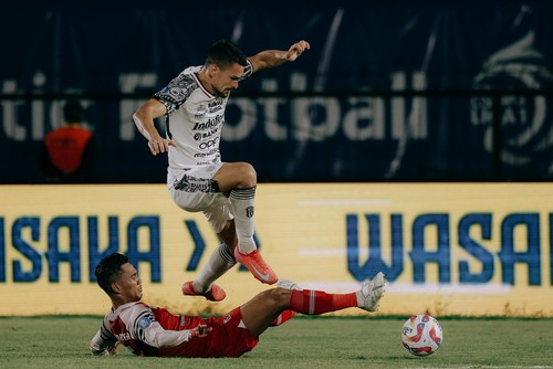 Striker Bali United Boris Kopitovic (jersey putih) melewati pemain Barito Putera, Tegar Infantrie, di Stadion Demang Lehman, Martapura, Kalimantan Selatan, Senin (24/2/2025). (Foto: Dok. Bali United)