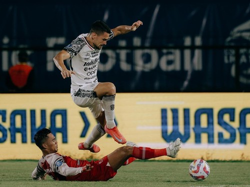 Striker Bali United Boris Kopitovic (jersey putih) melewati pemain Barito Putera, Tegar Infantrie, di Stadion Demang Lehman, Martapura, Kalimantan Selatan, Senin (24/2/2025). (Foto: Dok. Bali United)