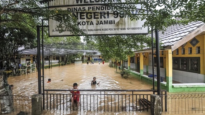 Banjir Rendam Ratusan Rumah dan Sekolah di Jambi Sejumlah anak bermain air di halaman SDN 98 Kota Jambi yang terendam banjir di Kelurahan Suka Karya, Jambi, Selasa (25/2/2025). Sebanyak 400 jiwa lebih dan sekitar 140 rumah terdampak banjir di kelurahan tesrebut akibat luapan Sungai Kenali Asam setelah kota itu diguyur hujan lebat pada Selasa (25/2/2025) dini hari. ANTARA FOTO/Wahdi Septiawan/YU