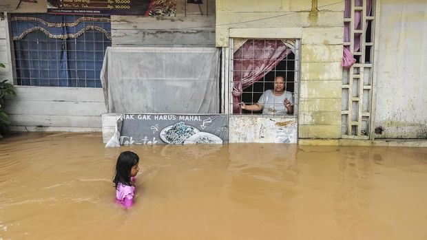 Sejumlah anak bermain air di halaman SDN 98 Kota Jambi yang terendam banjir di Kelurahan Suka Karya, Jambi, Selasa (25/2/2025). Sebanyak 400 jiwa lebih dan sekitar 140 rumah terdampak banjir di kelurahan tesrebut akibat luapan Sungai Kenali Asam setelah kota itu diguyur hujan lebat pada Selasa (25/2/2025) dini hari. ANTARA FOTO/Wahdi Septiawan/YU