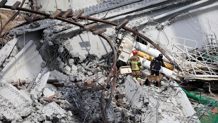 Konstruksi Tol Layang di Korsel Ambruk, 2 Orang Tewas Rescue workers participate in a salvage operation at a collapsed highway construction site in Cheonan, South Korea, February 25, 2025. REUTERS/Kim Hong-ji