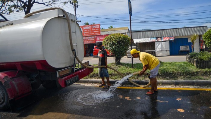 Pengendara melintas di antara debu yang beterbangan di Jalan Raya Indarung, Padang, Sumatera Barat, Selasa (25/2/2025). Debu akibat tumpahan material dari truk pengangkut hasil pertambangan itu mengganggu pengendara yang melintas. ANTARA FOTO/Iggoy el Fitra/YU