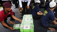Petugas rutan berkeliling untuk membagikan menu makan siang kepada para tahanan.  