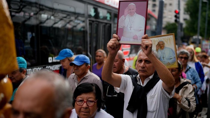 People attend a Mass to pray for Pope Francis' health in Constitution square in Buenos Aires, Argentina, Monday, Feb. 24, 2025. (AP Photo/Natacha Pisarenko)