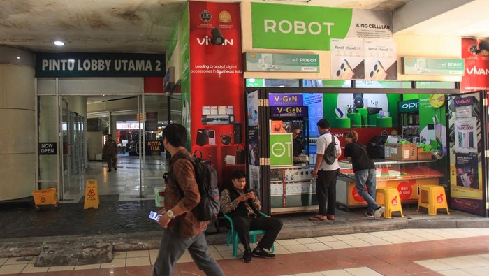 Dua karyawan toko menunggu dagangan di salah satu toko di Glodok Plaza, Tamansari, Jakarta, Selasa (25/2/2025). Sebagian pedagang di lantai 1 dan 2 pusat perbelanjaan elektronika tersebut kembali membuka toko mereka usai peristiwa kebakaran pada 15 Januari lalu. ANTARA FOTO/Reno Esnir/app/nz