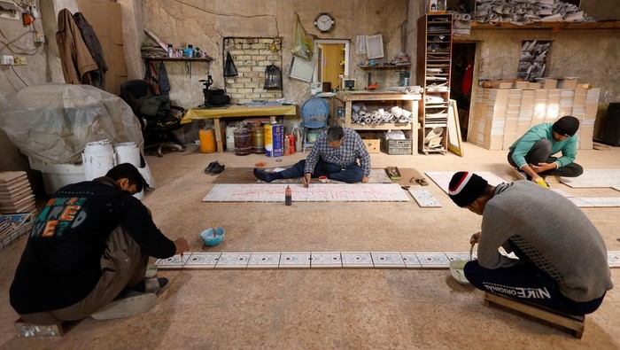 Ubin Buatan Tangan dari Karbala Irak Menjaga Seni Bersejarah Tetap Hidup People work on traditional ceramic tiles, adorned with Islamic calligraphy and phrases, in the holy city of Karbala, Iraq, February 11, 2025. These decorative tiles made of clay have been part of Kerbala's artistic heritage for centuries, embellishing old mosques and holy shrines. REUTERS/Alaa Al-Marjani